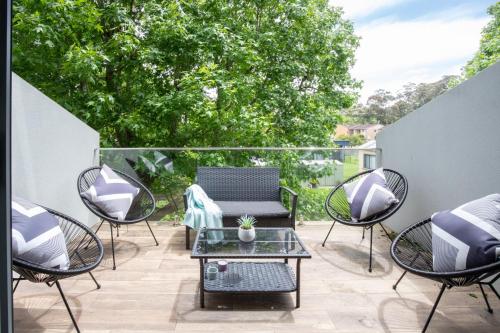 a patio with chairs and a table on a patio at Generous 2-Bed Townhouse With A Private Balcony in Batemans Bay