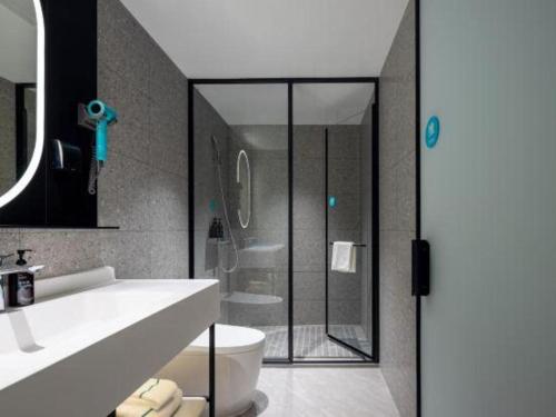 ein Badezimmer mit Dusche, Toilette und Waschbecken in der Unterkunft City Comfort Inn Hechi Bama Shouxiang Avenue in Bama