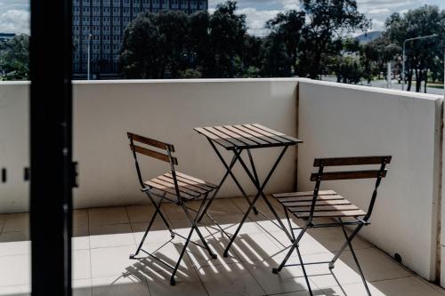 two chairs and a table on a balcony at Urban 1-Bed Apartment in the Heart of the City in Canberra