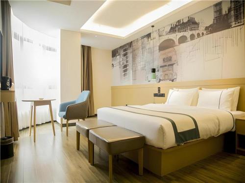 a hotel room with a large bed and a chair at City Comfort Inn Wanning Wan'An Avenue High Speed Railway Station in Wanning