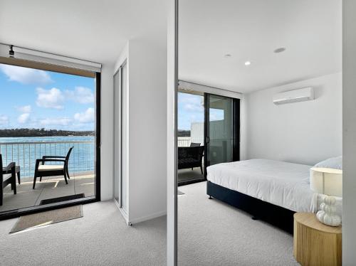 a bedroom with a bed and a view of the water at Deluxe 3-Bed Unit with Views in Batemans Bay