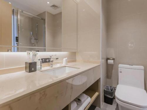 ein weißes Badezimmer mit Waschbecken und Toilette in der Unterkunft City Comfort Inn Foshan Gaoming Huaying Square in Shilong