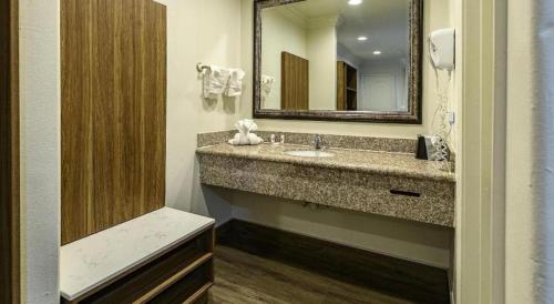 a bathroom with a sink and a mirror at Rodeway Inn Carlsbad in Carlsbad
