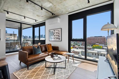 a living room with a couch and large windows at Executive 2-Bed Apartment with Views, Gym and Pool in Melbourne