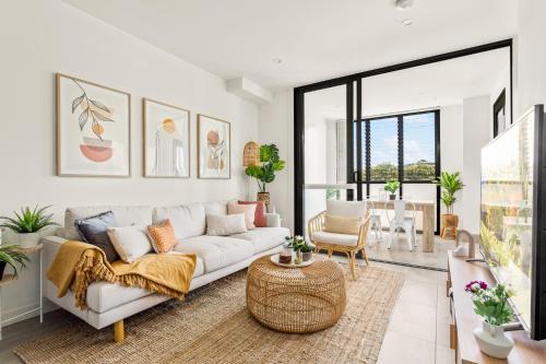 a living room with a white couch and a table at Coastal 2-Bed Apartment near Beach in Deewhy