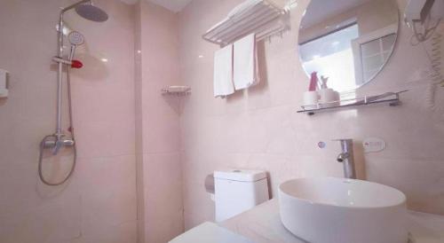 ein weißes Badezimmer mit Waschbecken und Dusche in der Unterkunft Thank Inn Hotel Sichuan Zigong Ziliujing District Wuxing Street in Zigong