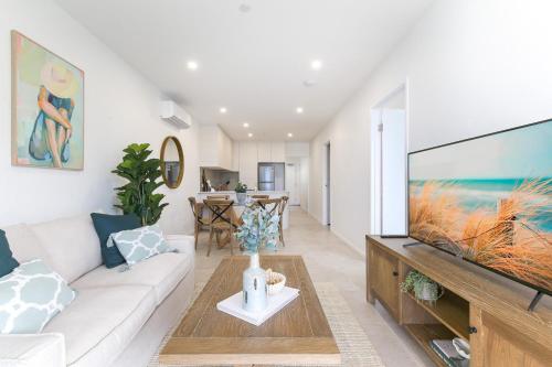 a living room with a large flat screen tv at Oceanside Apartment with Bay Views in Batemans Bay