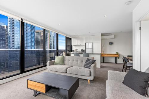 a living room with a couch and a table at Pristine 2-Bed Unit With Beautiful City Landscape in Melbourne