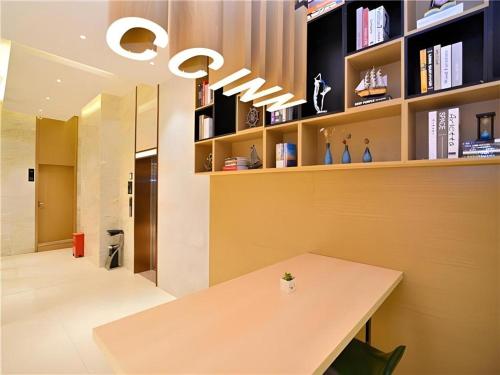 une salle à manger avec une table et une étagère à livres dans l'établissement City Comfort Inn Kunming High-speed Railway South Station 7th Street Area, à Kunming