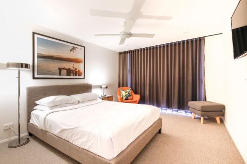 a bedroom with a large bed and a window at Chic 2-bed Bridgeview Apartments Batemans Bay in Batemans Bay