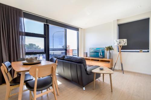 una sala de estar con un sofá y una mesa en Gorgeous 2-Bed Apartment By Shops and the River, en Batemans Bay