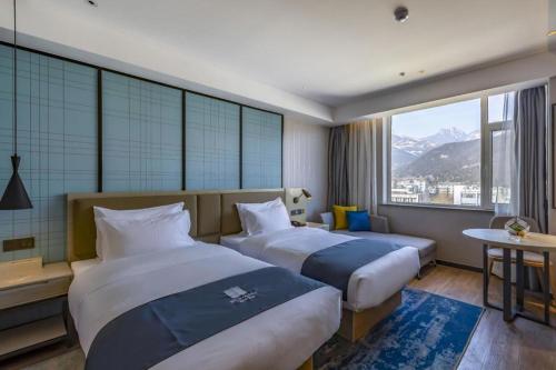 une chambre d'hôtel avec deux lits et une fenêtre dans l'établissement Echarm Hotel Tai'an Taishan Tianwai Village Hongmen, à Tai'an