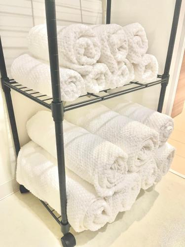 a pile of towels on a towel rack in a bathroom at Trh Sophia in Miyazaki