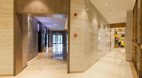 un couloir d'un immeuble avec un grand mur de verre dans l'établissement Echarm Hotel Tai'an Taishan Tianwai Village Hongmen, à Tai'an