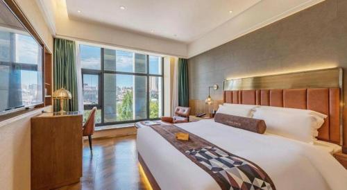 ein Schlafzimmer mit einem großen Bett und einem großen Fenster in der Unterkunft James Joyce Coffetel Tianjing First Central Hospital Nankai University in Tianjin