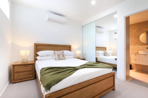 a bedroom with two beds and a mirror at Glorious 2-Bed with Waterside Balcony Views in Batemans Bay