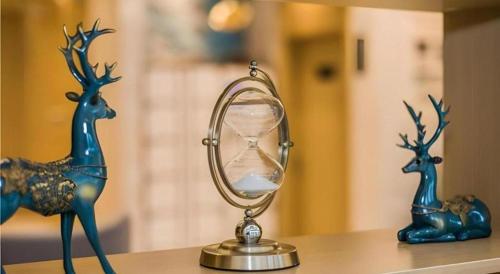 un bureau avec un réveil et un sablier ancien dans l'établissement City Comfort Inn Kunshan Development Zone Penglang Xinxing Middle Road, à Penglang