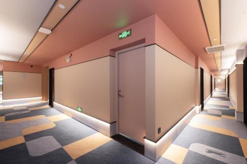 an empty corridor with doors in a building at Hanting Hotel Shanghai Xujiahui Jiaotong University Yishan Road in Shanghai