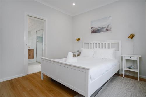 a white bedroom with a white bed and a window at Exquisitely Spacious 3-Bed Home in Fyshwick