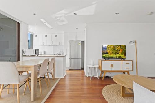 a kitchen and dining room with a table and chairs at Prime Location 2-Bed Apartment with Parking in Sydney