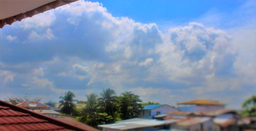 a view of a cloudy sky with buildings and palm trees at Al-Minar Hotel in Zanzibar City
