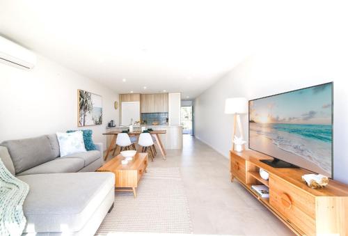 a living room with a large flat screen tv at Exquisite 1-Bed Apartment with Bay Views in Batemans Bay