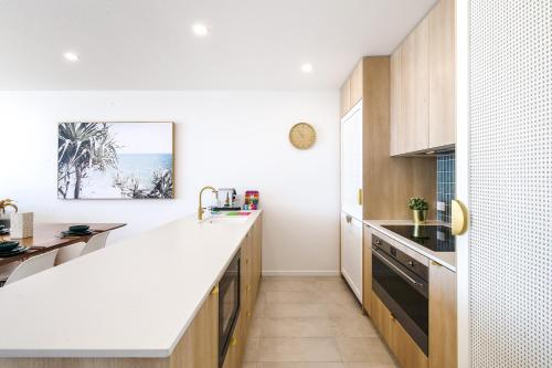 a kitchen with a white counter top and a table at Exquisite 1-Bed Apartment with Bay Views in Batemans Bay