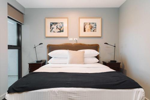 a bedroom with a large bed with white pillows at Stunning 1-Bed Above Foreshore with Water Views in Kingston