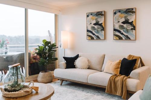 a living room with a couch and a table at Lakeside 3-Bed Apartment with Jacuzzi in Belconnen