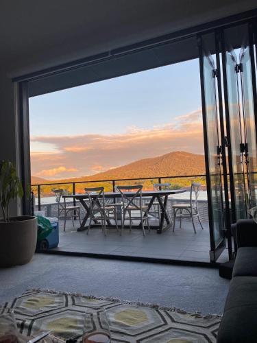 a patio with a table and chairs on a balcony at Mountain View City Center Apartment with BBQ in Canberra