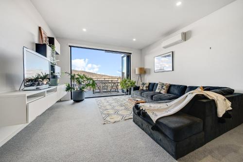 a living room with a couch and a television at Mountain View City Center Apartment with BBQ in Canberra
