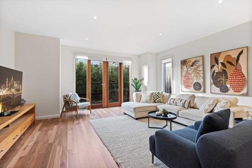 a living room with a couch and a tv at Chic 2-Bed Home By Bustling Shops in Yarraville