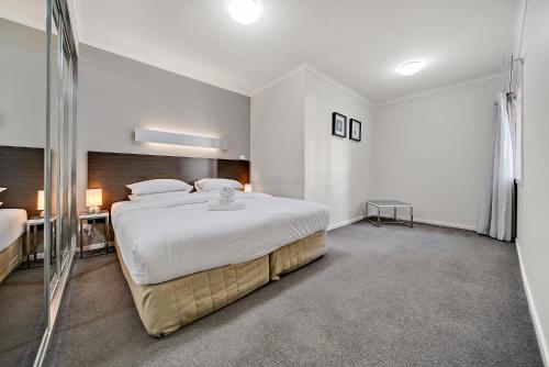 a bedroom with a large white bed in a room at Comfy 2-Bed Near the Lake with Secure Parking in Tuggeranong