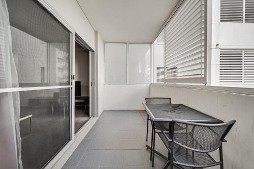 a table and chairs in a room with a window at Comfy 2-Bed Near the Lake with Secure Parking in Tuggeranong