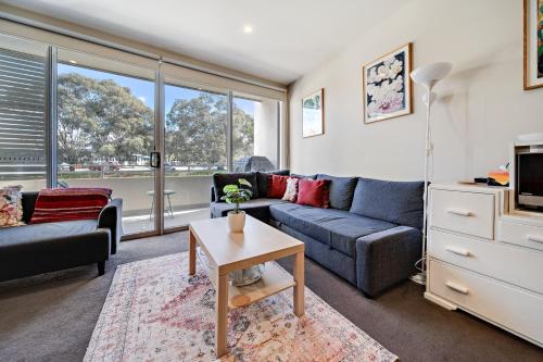 a living room with a couch and a table at Tranquil Apartment in Green, Well Connected Suburb in Lyons