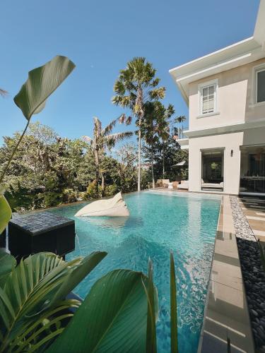 a swimming pool in front of a house at Kula Kara Villas Bingin, Uluwatu in Uluwatu