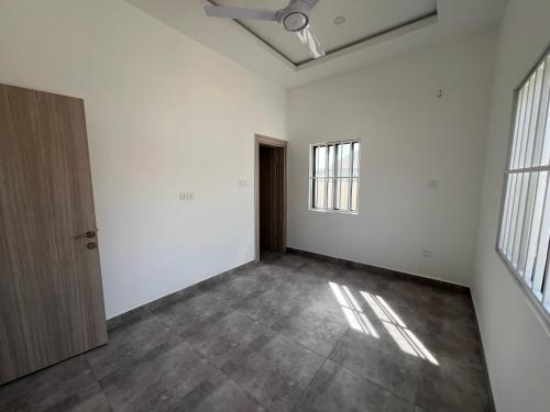 una habitación vacía con paredes blancas y una puerta en TAF City Home, en Sifoe