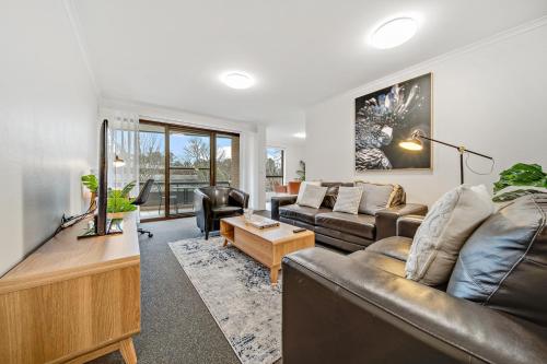 a living room with a couch and a table at 2-Bed with Pool, BBQ, Tennis Court & Parking in Kingston