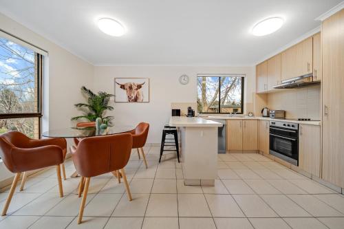 cocina con mesa, sillas, mesa y barra en 2-Bed with Pool, BBQ, Tennis Court & Parking, en Kingston 