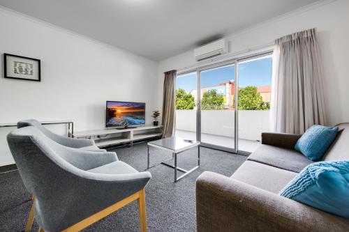 a living room with a couch and a tv at Spacious 2-Bed Conveniently by Lake Tuggeranong in Tuggeranong