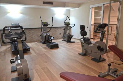 a gym with several tread machines in a room at Vea Resort Hotel in Mercato San Severino