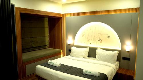 a bedroom with a bed with a large window at The Lovedale Kodaikanal Stay & Hotel in Kodaikānāl