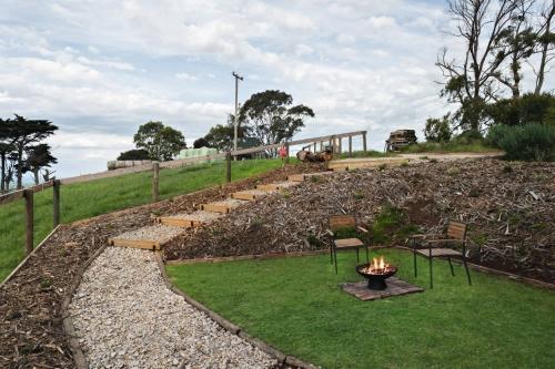 un giardino con sedie e un braciere nell'erba di Mountain Views X by Tiny Away a Yarragon