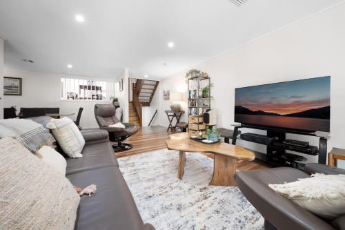 a living room with a couch and a flat screen tv at Gorgeous 2-Bed Townhouse with Patio, BBQ & Parking in Kingston