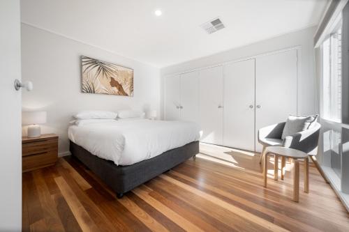 a bedroom with a bed and a chair and a table at Gorgeous 2-Bed Townhouse with Patio, BBQ & Parking in Kingston