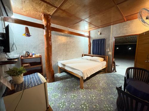 a bedroom with a bed in the middle of a room at ลีลา รีสอร์ท Leela Resort in Ban Tha Phae