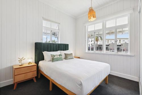 a white bedroom with a bed and a window at Tranquil 3-Bed Family Home with Spacious Backyard in Brisbane