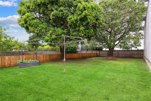 a yard with a basketball hoop and a tree at Tranquil 3-Bed Family Home with Spacious Backyard in Brisbane