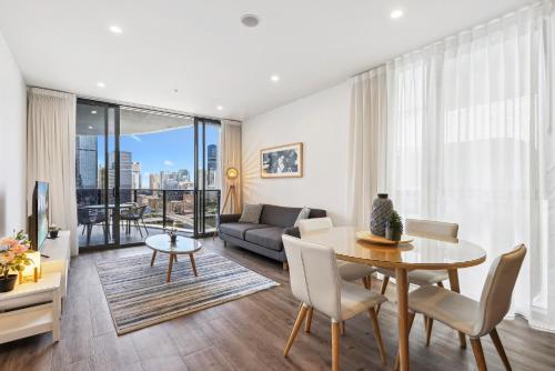a living room with a table and a couch at Chic 2-Bed with Rooftop Pool Overlooking the City in Brisbane