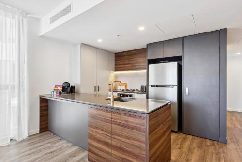 a kitchen with a counter and a refrigerator at Chic 2-Bed with Rooftop Pool Overlooking the City in Brisbane